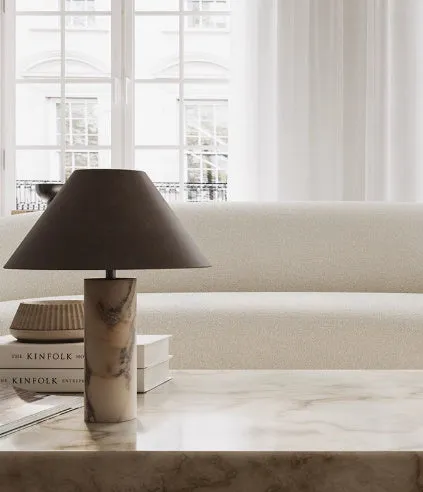 Modern black table lamp with a textured marble base on a wooden desk.