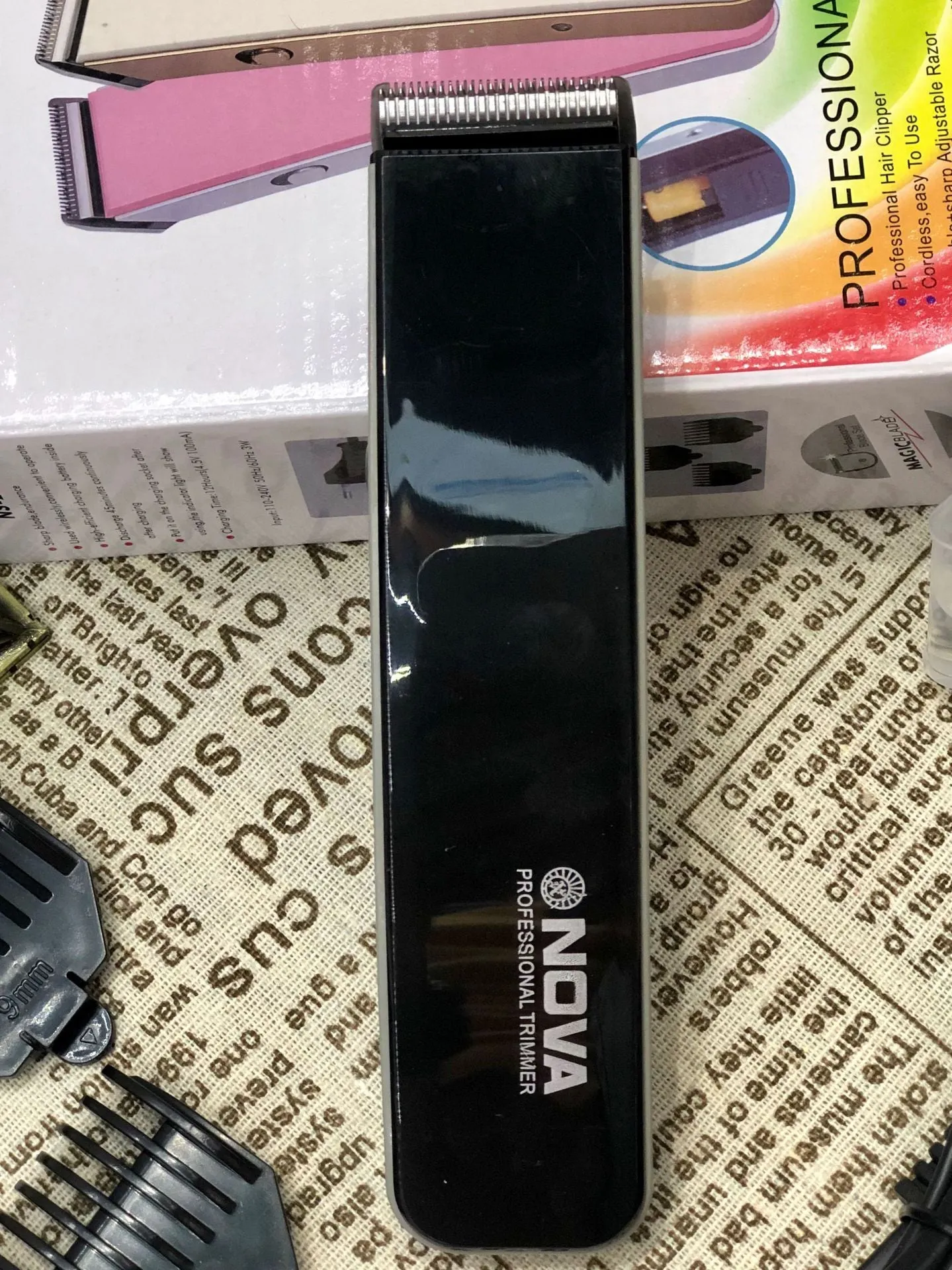 Black electric hair clipper with removable blade head on a white background.