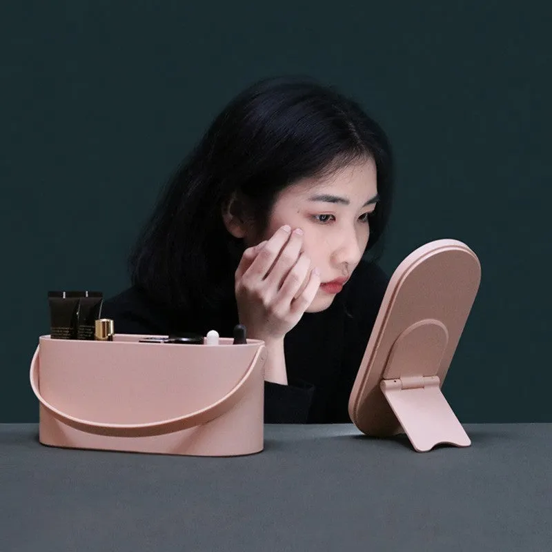 Portable pink plastic storage box with a built-in rectangular aluminium makeup mirror.