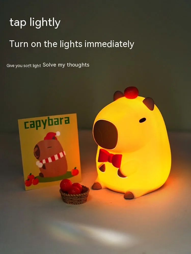 Cute brown Capybara silicone night lamp with soft glow on a bedside table.