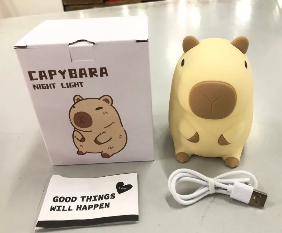 Cute brown Capybara silicone night lamp with soft glow on a bedside table.