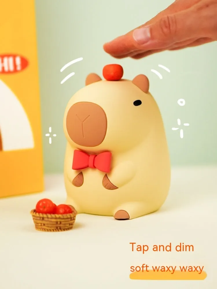 Cute brown Capybara silicone night lamp with soft glow on a bedside table.