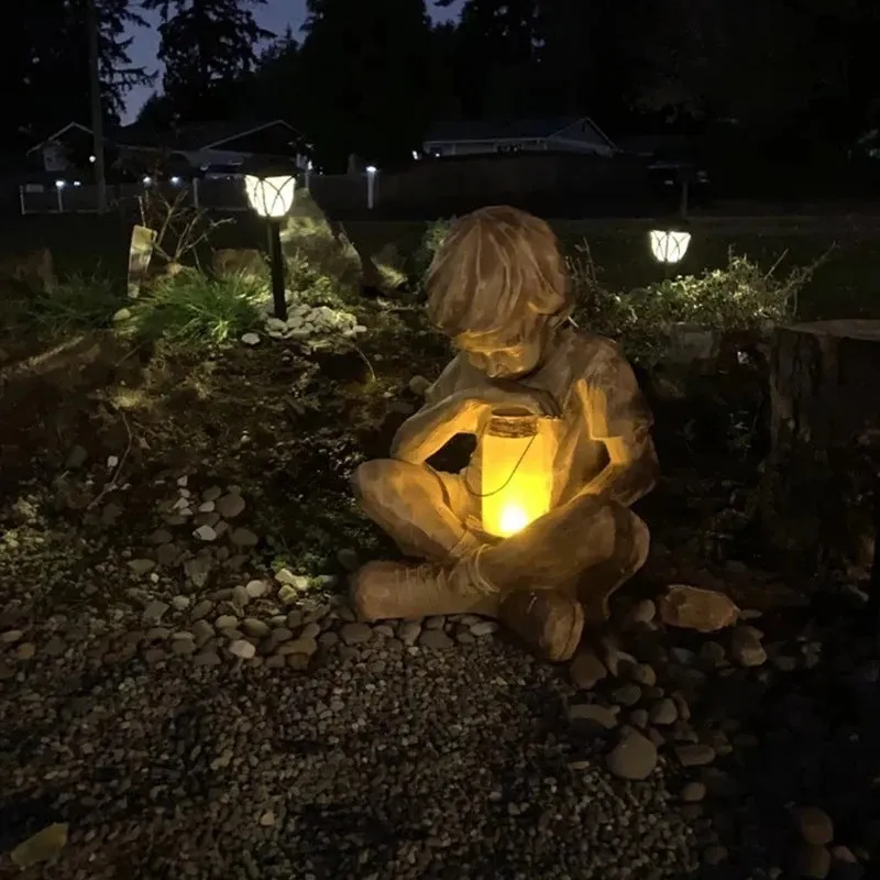 Brown natural resin statue of a little boy garden ornament for tabletop decoration.
