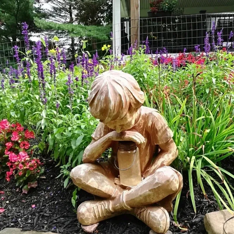 Brown natural resin statue of a little boy garden ornament for tabletop decoration.