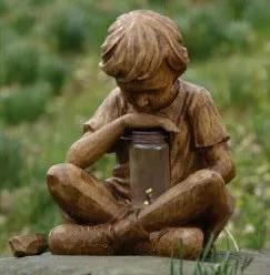 Brown natural resin statue of a little boy garden ornament for tabletop decoration.