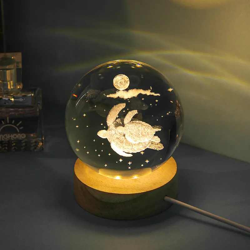 Transparent crystal ball night lamp with carved jellyfish design illuminated by internal LED light
