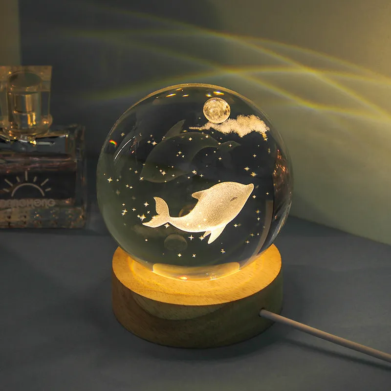 Transparent crystal ball night lamp with carved jellyfish design illuminated by internal LED light