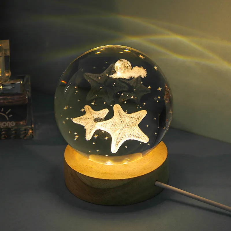 Transparent crystal ball night lamp with carved jellyfish design illuminated by internal LED light