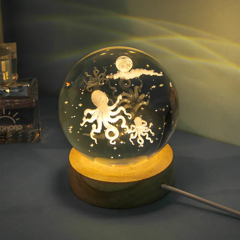 Transparent crystal ball night lamp with carved jellyfish design illuminated by internal LED light