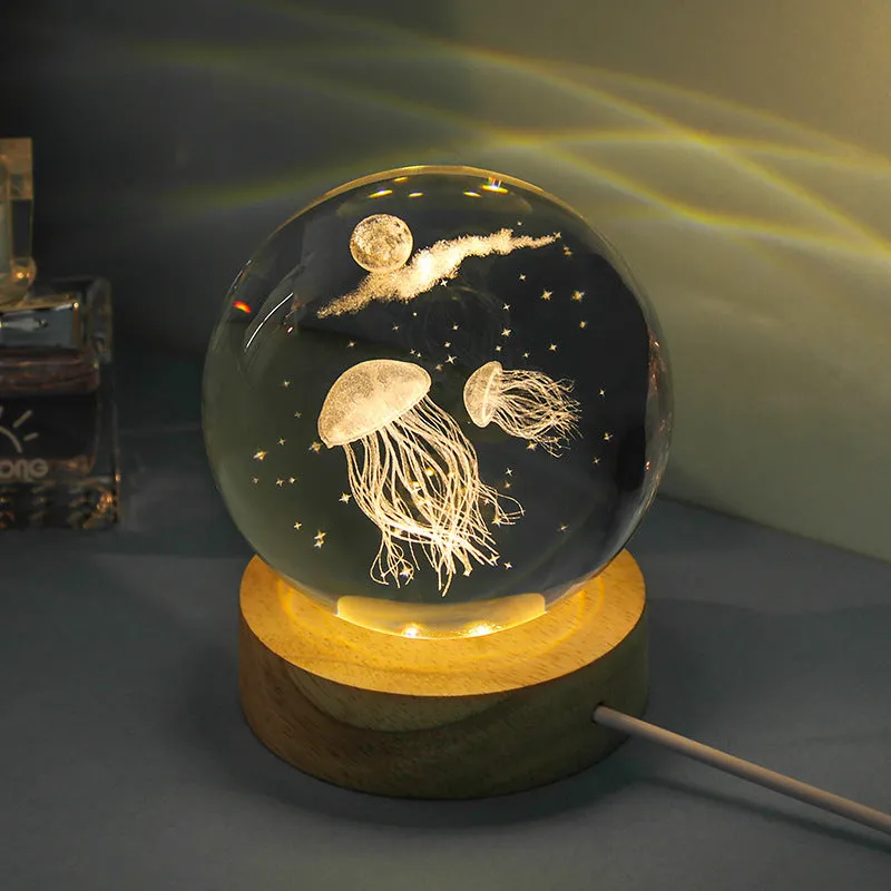 Transparent crystal ball night lamp with carved jellyfish design illuminated by internal LED light