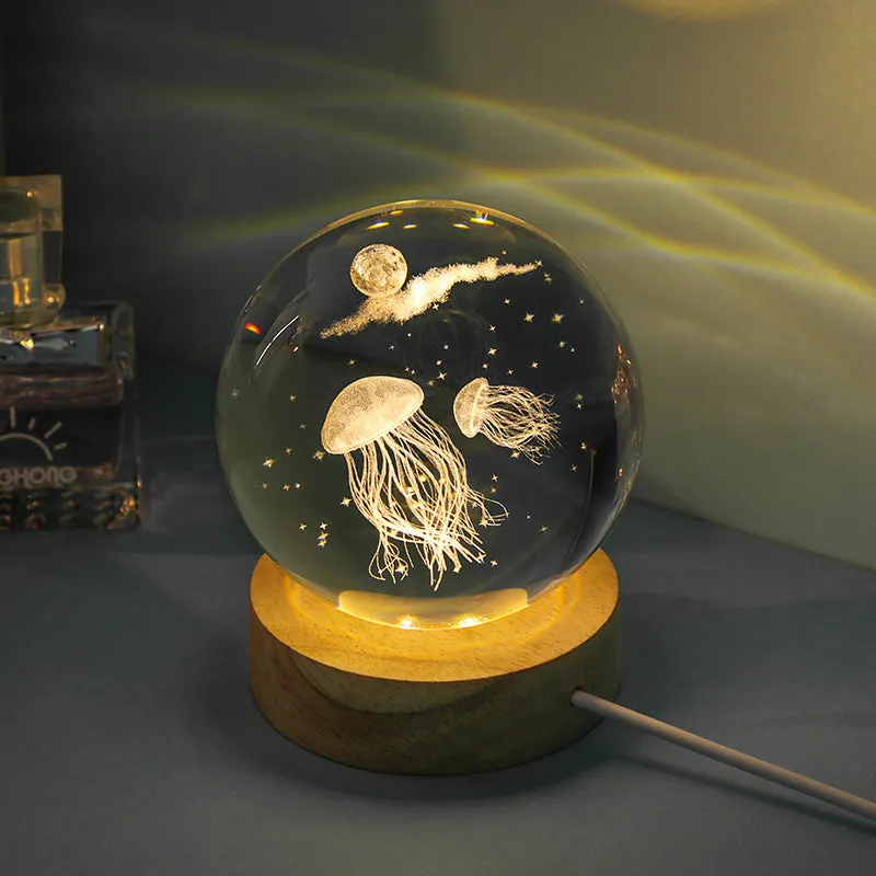 Transparent crystal ball night lamp with carved jellyfish design illuminated by internal LED light