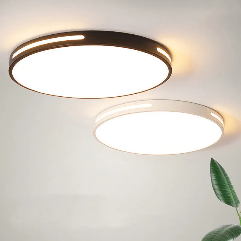 Round white acrylic remote control LED ceiling lamp mounted on a bedroom ceiling.