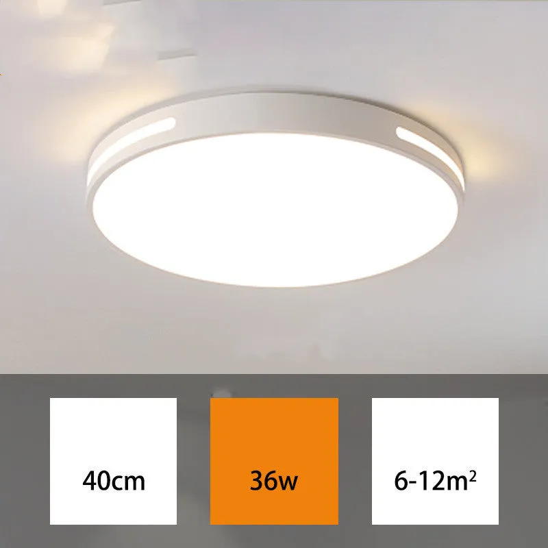 Round white acrylic remote control LED ceiling lamp mounted on a bedroom ceiling.