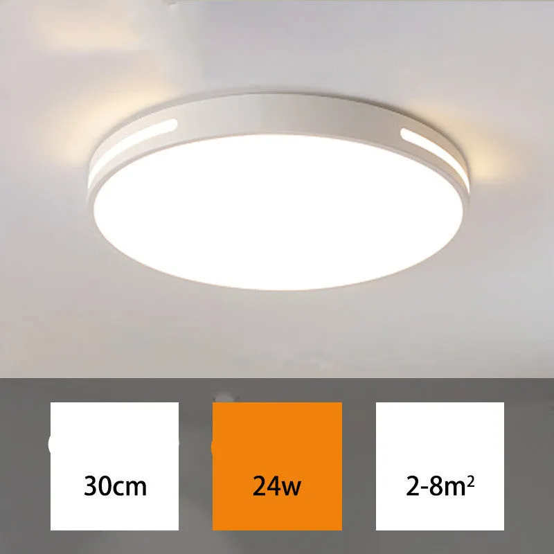 Round white acrylic remote control LED ceiling lamp mounted on a bedroom ceiling.