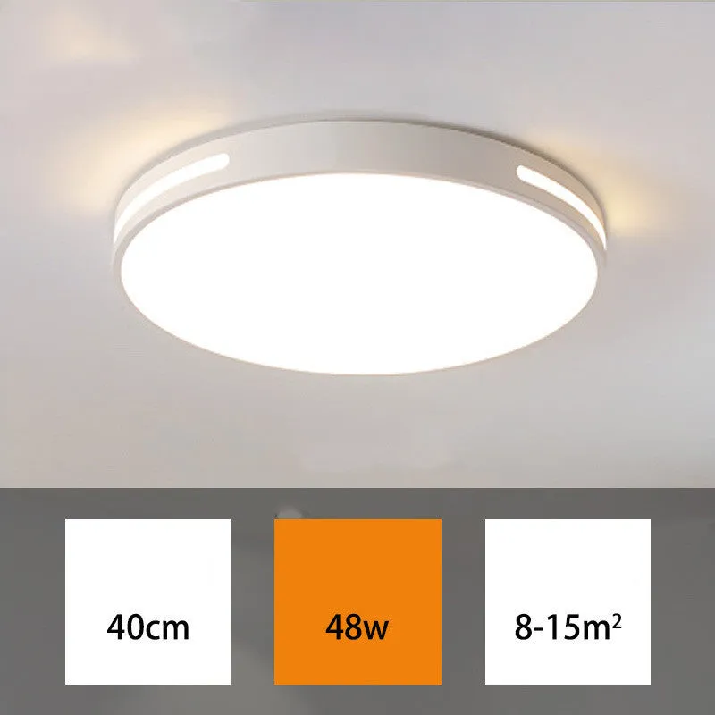 Round white acrylic remote control LED ceiling lamp mounted on a bedroom ceiling.