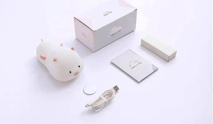 Blue rechargeable silicone night light shaped like a sleeping pig with soft LED glow.