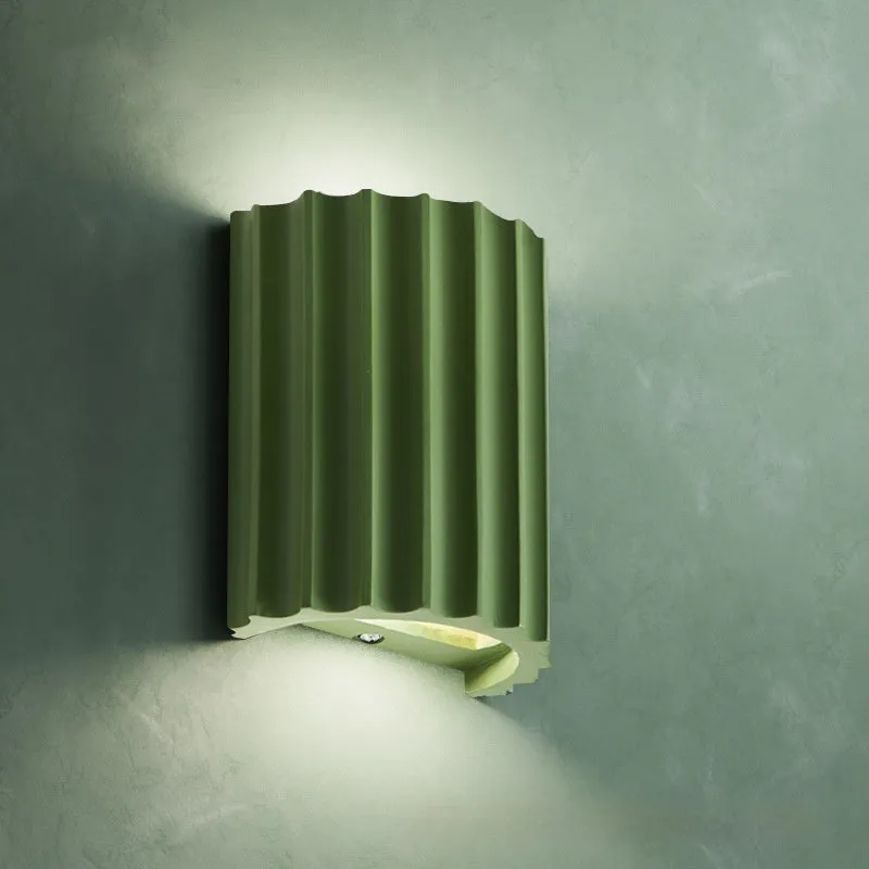 Nordic style wall light with a white macaron shell-shaped shade mounted on a hallway wall.