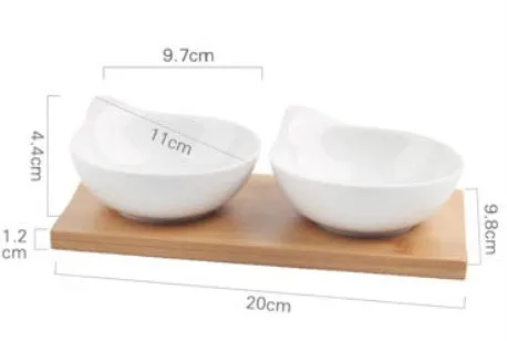 Porcelain ceramic dried fruit dish with three snack compartments on a wooden serving board.