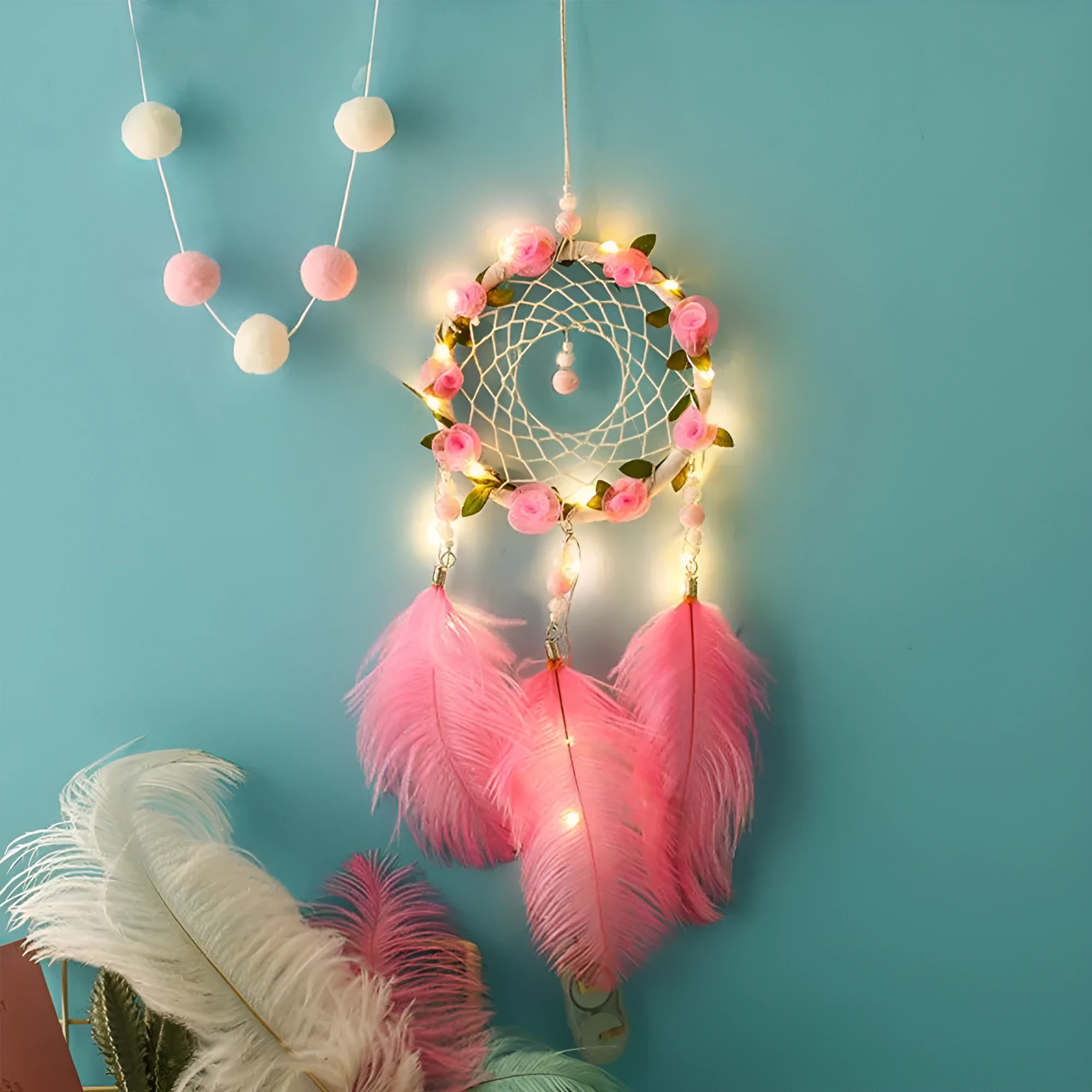 Close-up of a modern pink ostrich feather dreamcatcher wind chime wall ornament.