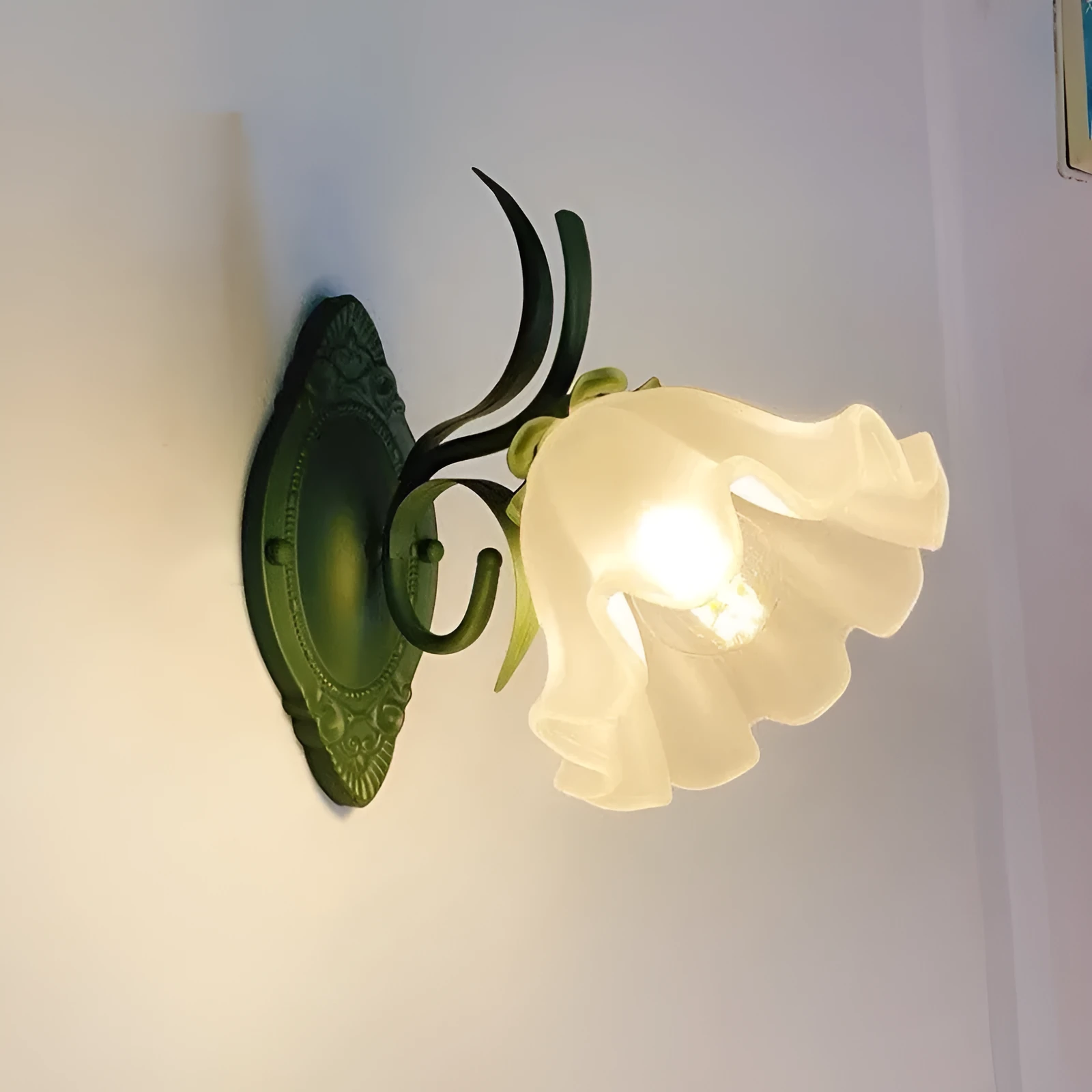 Green pastoral style flower-shaped wall lamp with a glass shade and integrated LED light.