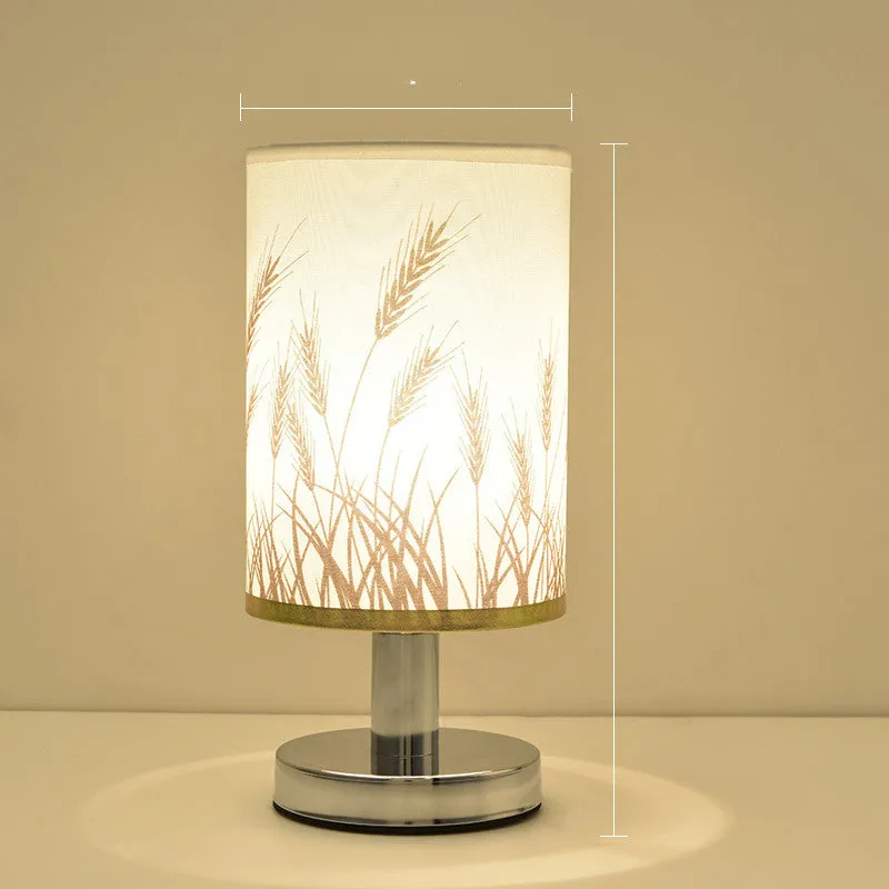 Small dimmable night light with cloth shade and iron base, showing remote control.