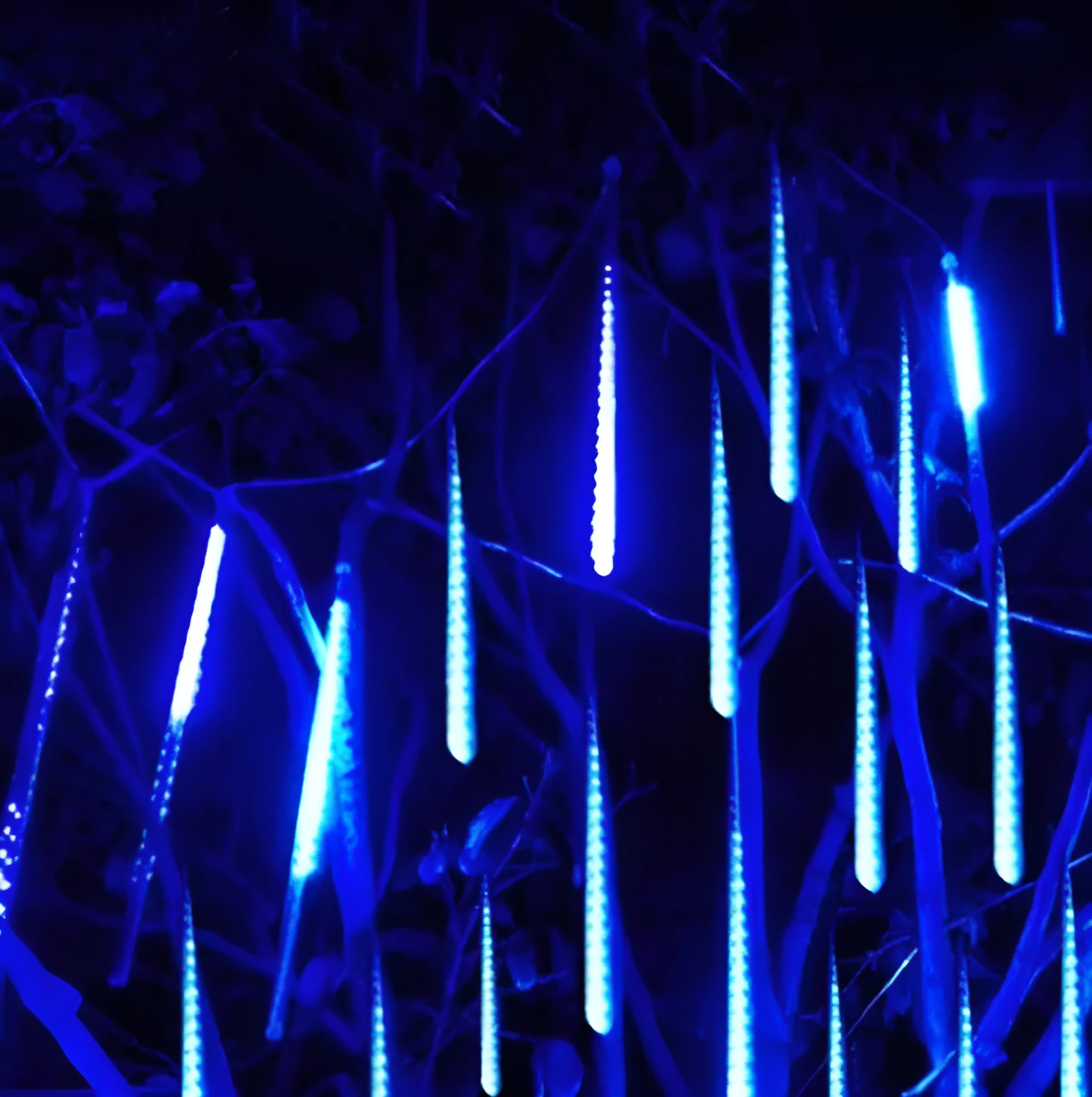 Waterproof LED meteor shower rain lights with multicolour effects in outdoor garden setting