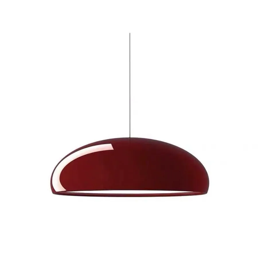 Danish iron pendant lamp in orange with adjustable cable hanging over a restaurant table.