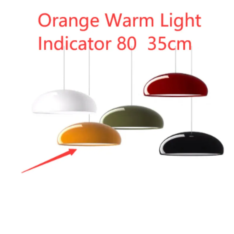 Danish iron pendant lamp in orange with adjustable cable hanging over a restaurant table.