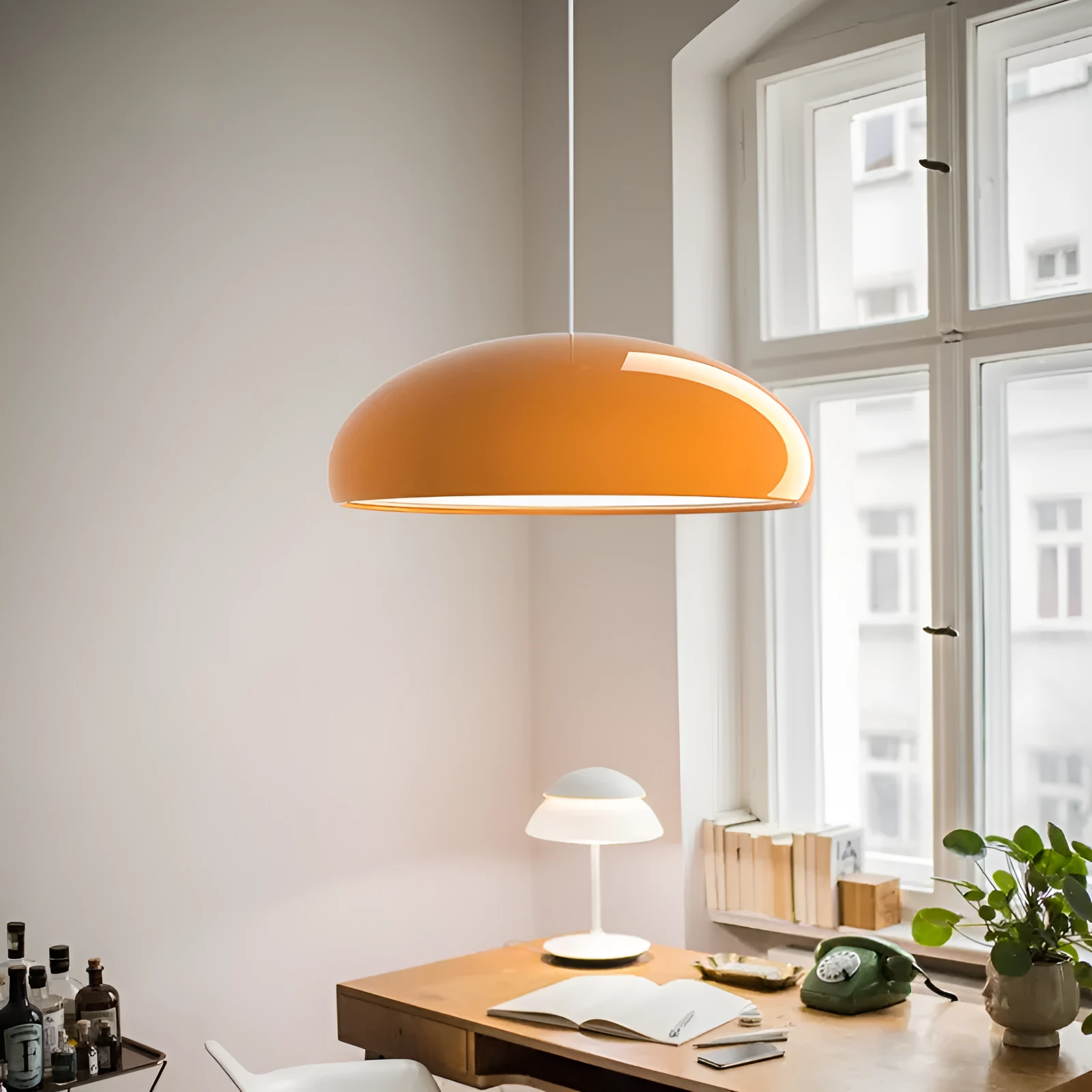 Danish iron pendant lamp in orange with adjustable cable hanging over a restaurant table.