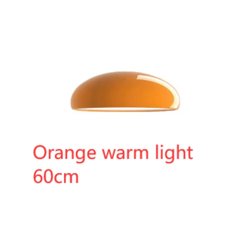 Danish iron pendant lamp in orange with adjustable cable hanging over a restaurant table.
