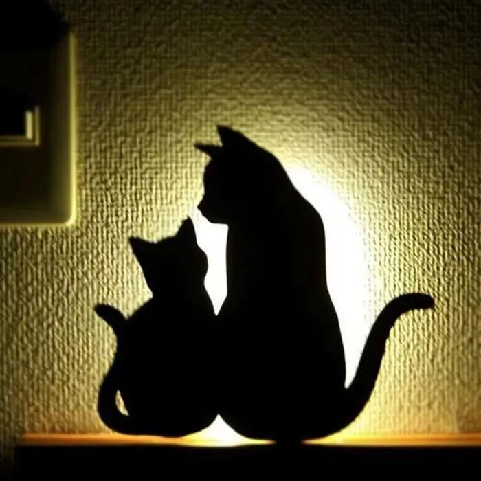 Black cartoon cat shaped LED night light with sound sensor for wall mounting.