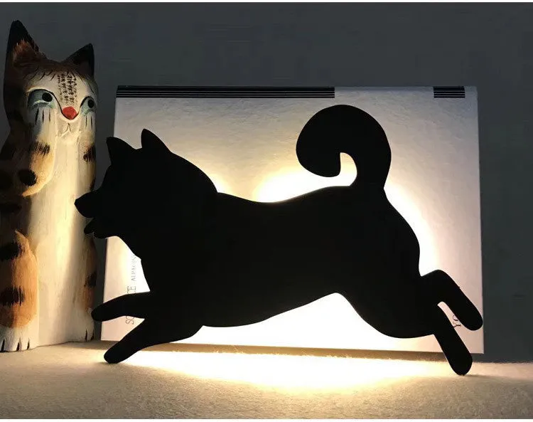 Black cartoon cat shaped LED night light with sound sensor for wall mounting.