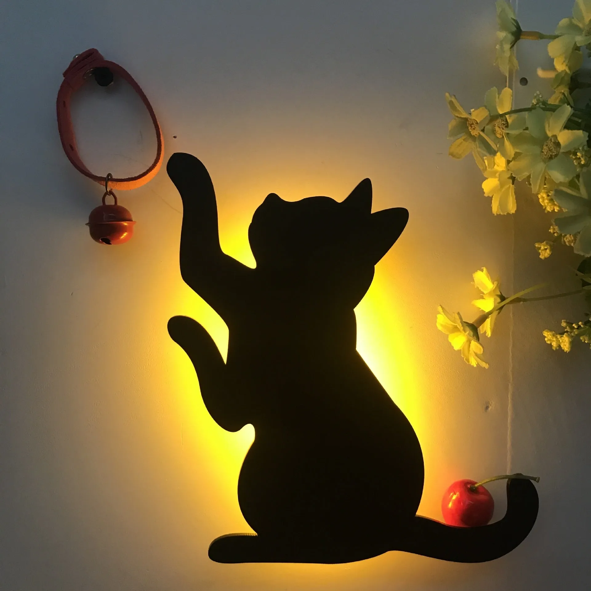 Black cartoon cat shaped LED night light with sound sensor for wall mounting.