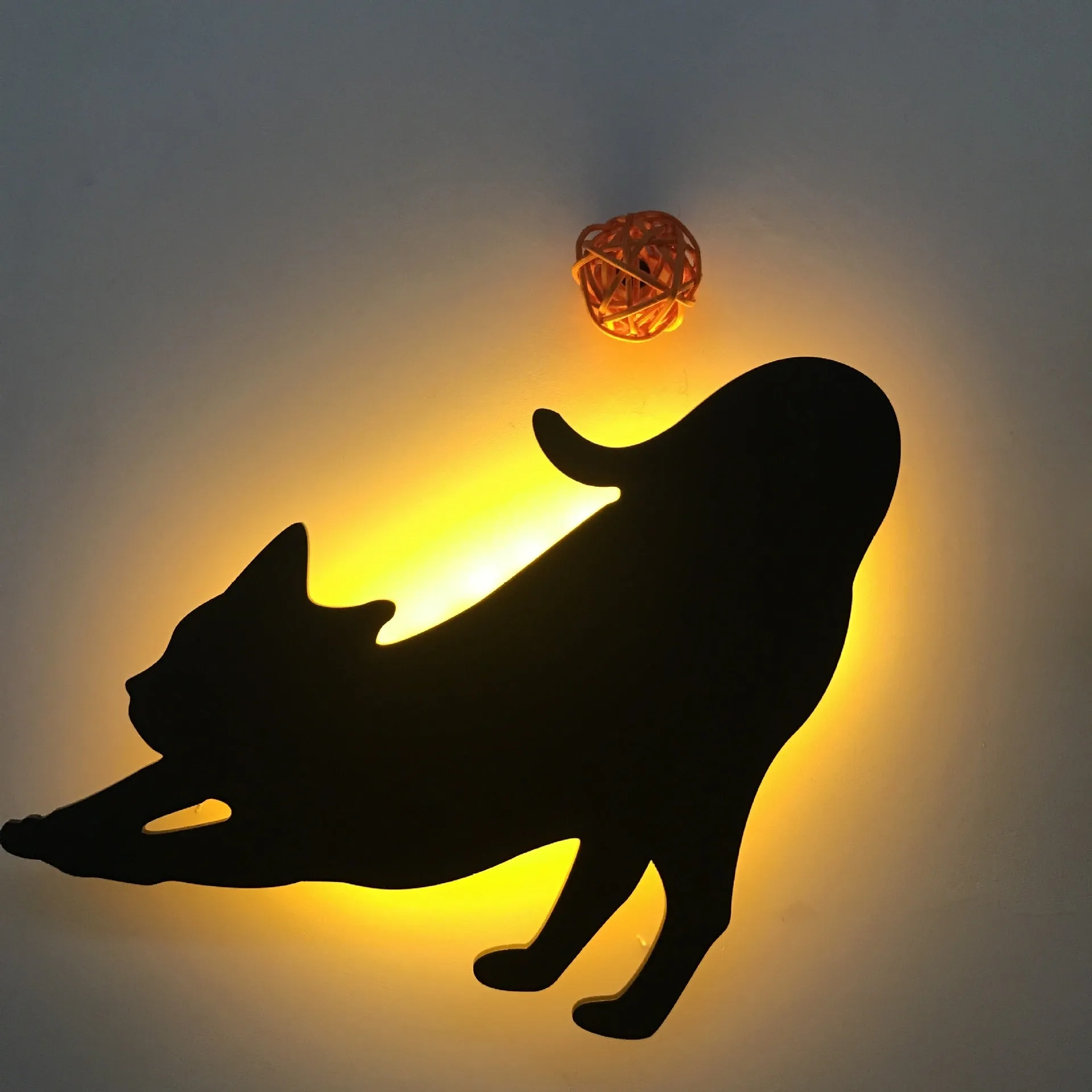 Black cartoon cat shaped LED night light with sound sensor for wall mounting.