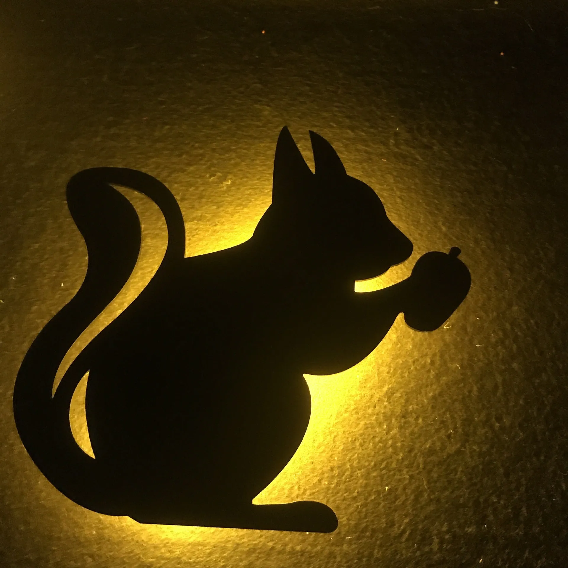 Black cartoon cat shaped LED night light with sound sensor for wall mounting.