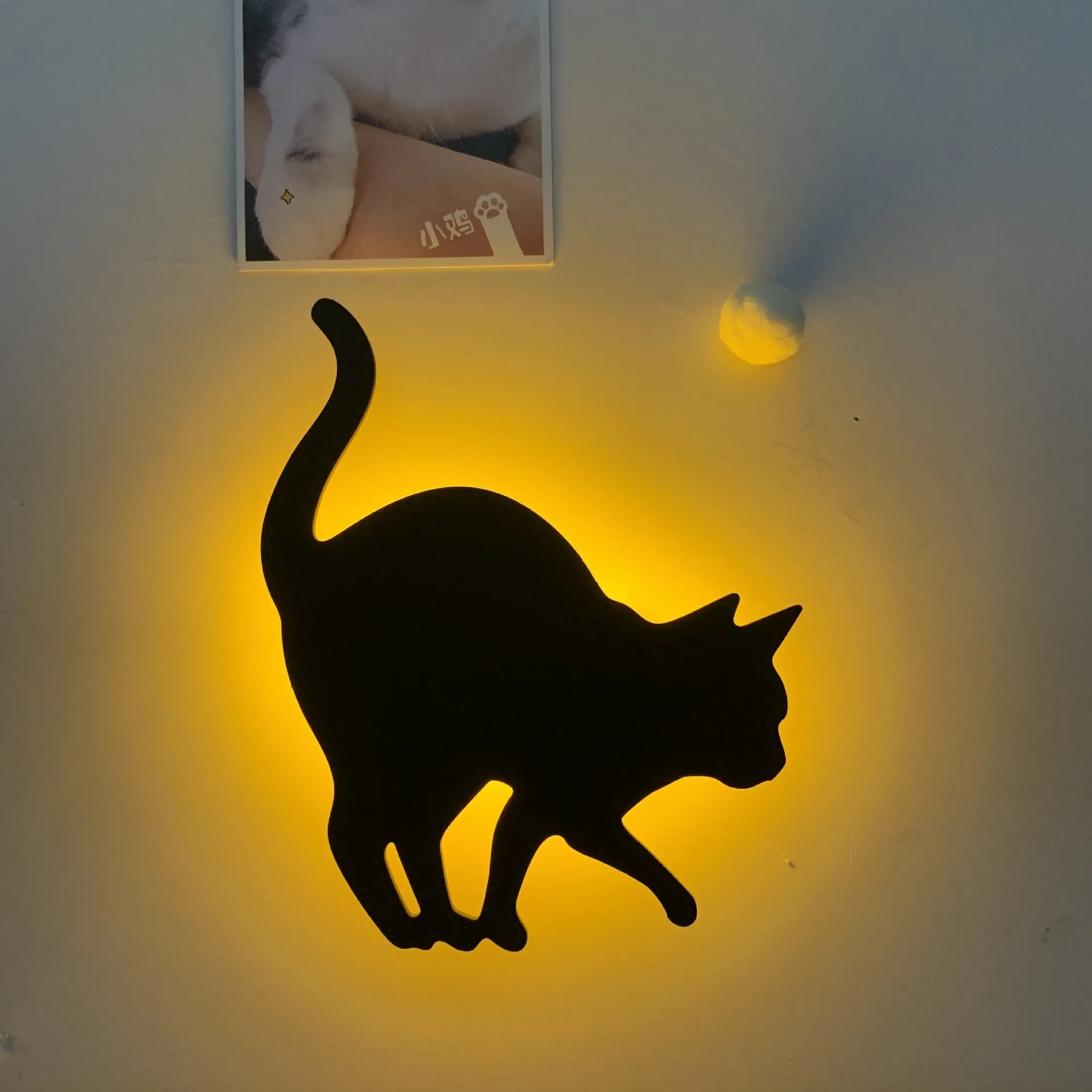 Black cartoon cat shaped LED night light with sound sensor for wall mounting.