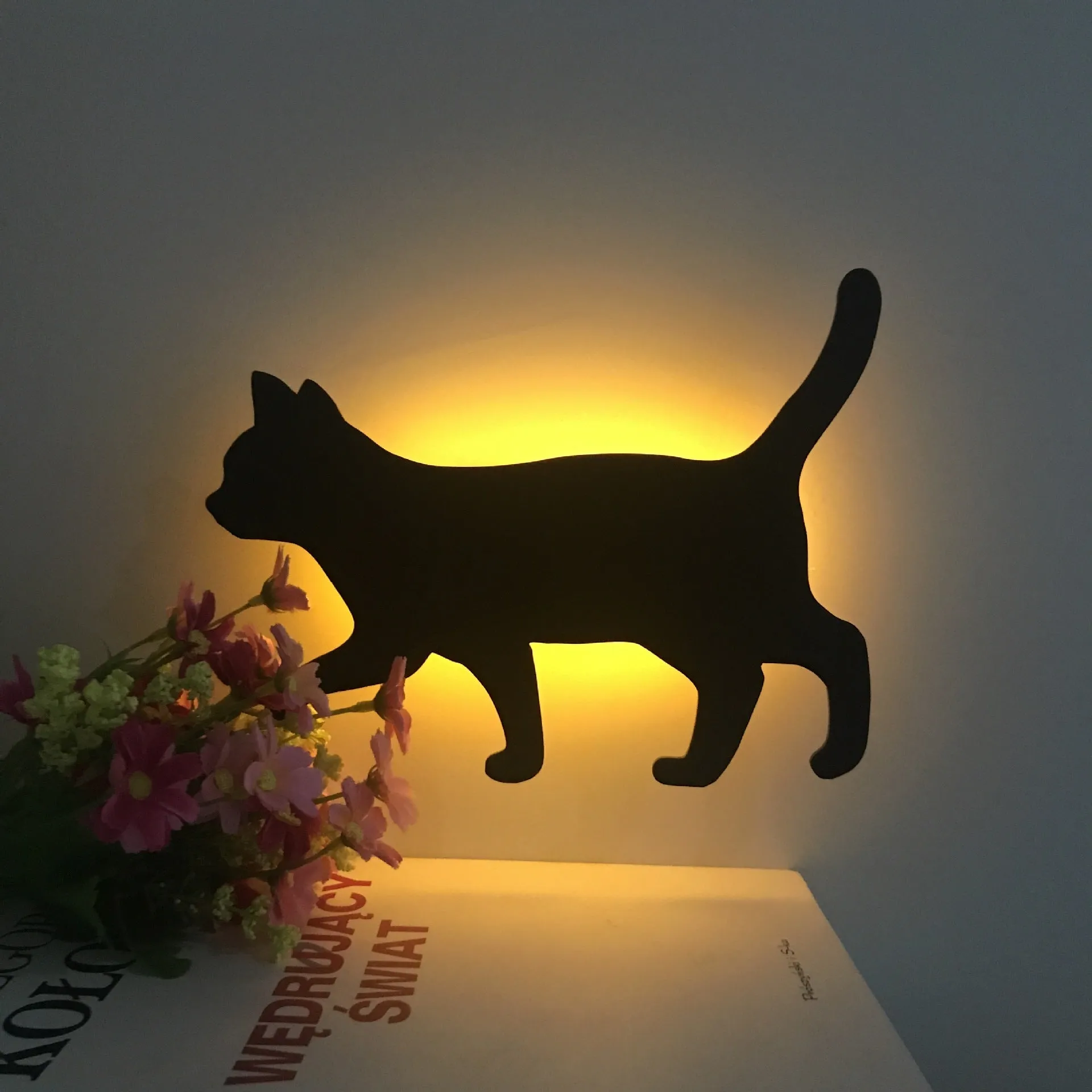 Black cartoon cat shaped LED night light with sound sensor for wall mounting.