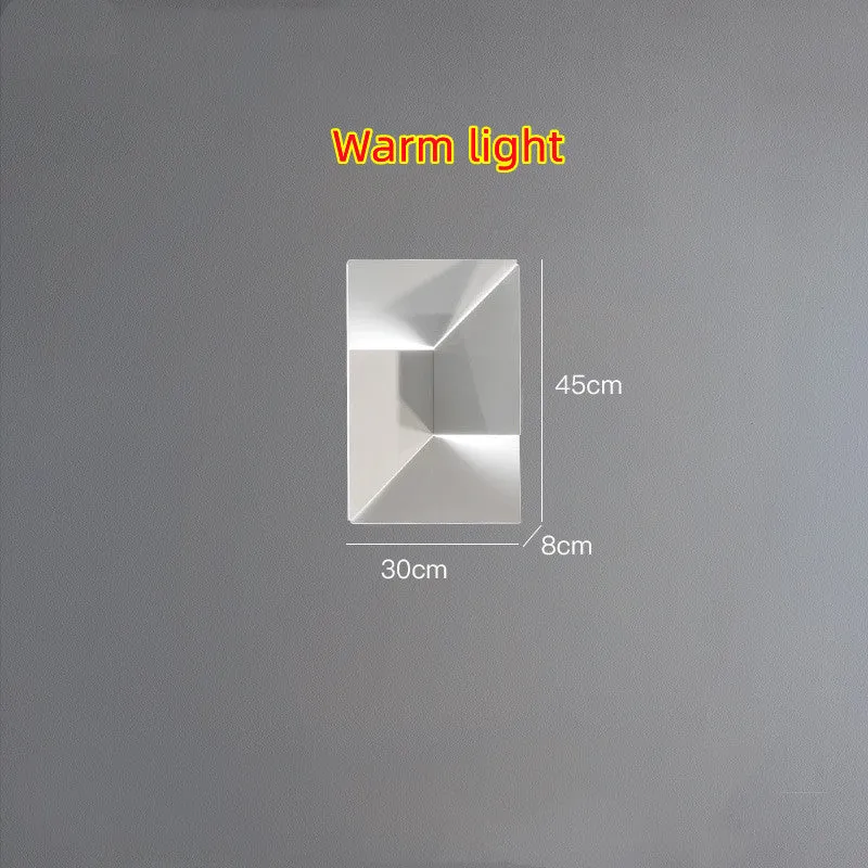 Minimalist rectangular wall lamp in matte white finish, shown in a living room setting.