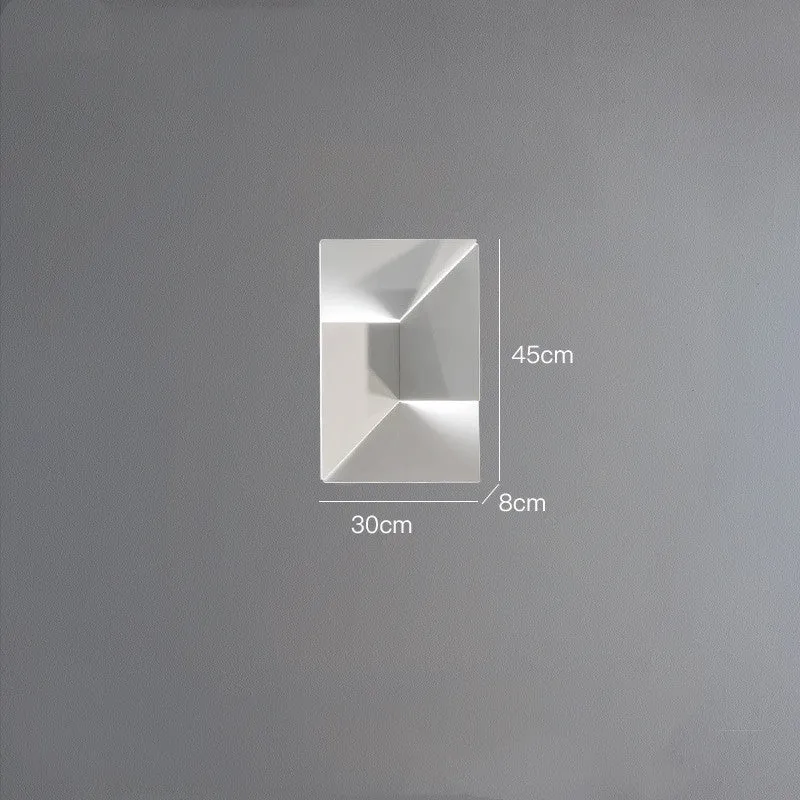 Minimalist rectangular wall lamp in matte white finish, shown in a living room setting.