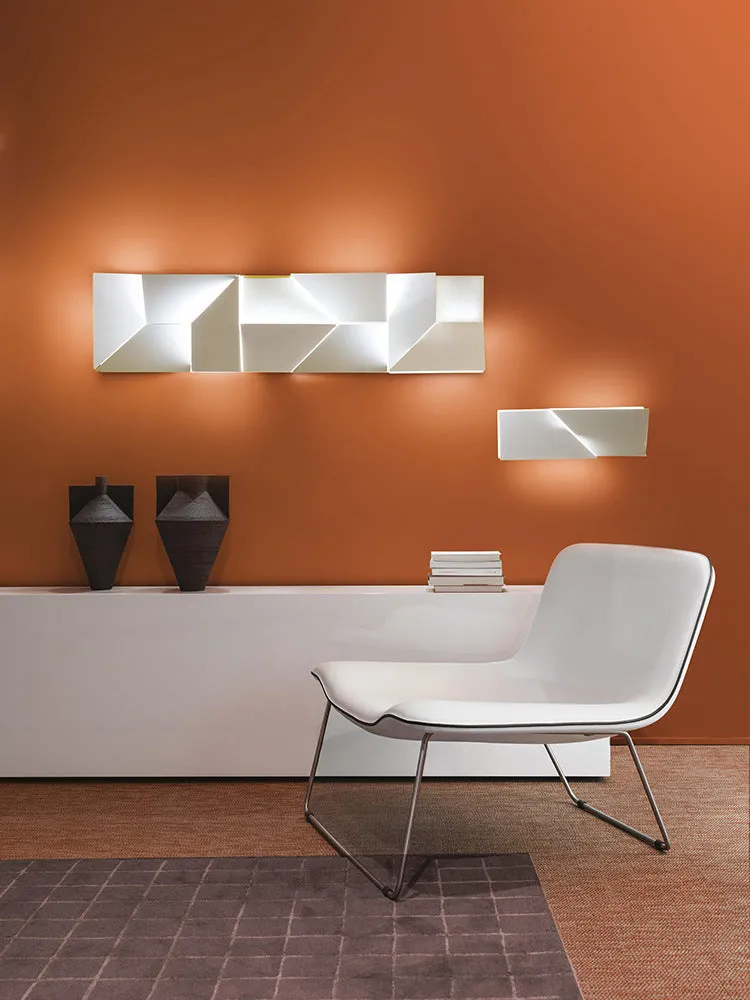Minimalist rectangular wall lamp in matte white finish, shown in a living room setting.