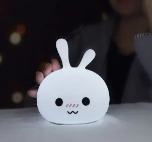 White marshmallow bunny LED night light with shy face or happy face option on a table.