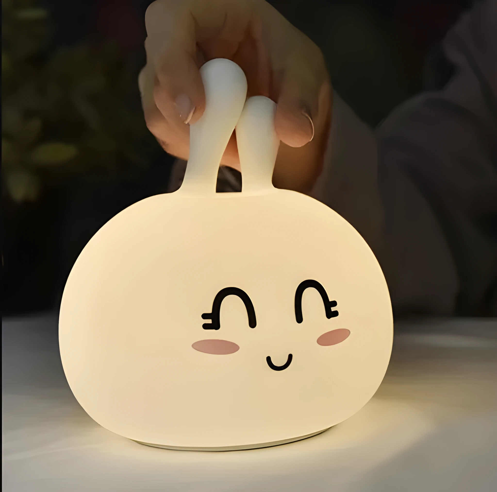 White marshmallow bunny LED night light with shy face or happy face option on a table.