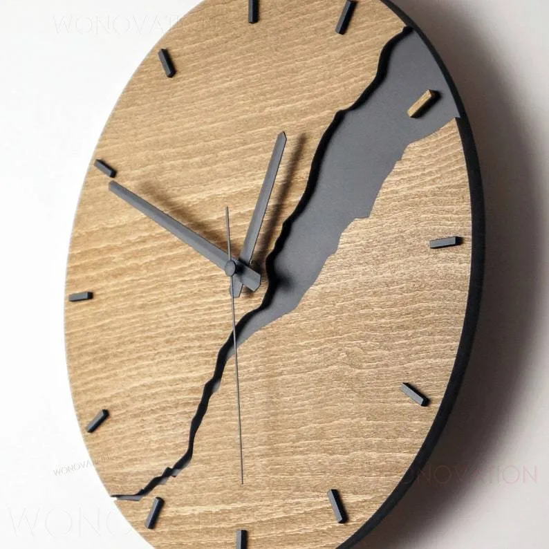 Modern simple wooden wall clock with a crack design dial on a light wood background.