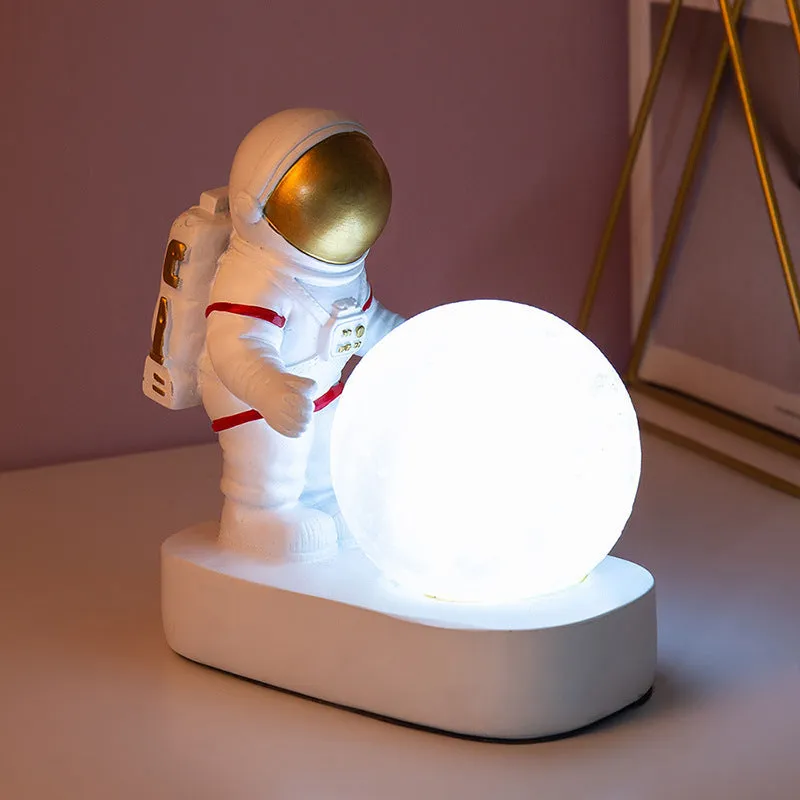 Gold resin astronaut night light on shelf, 14.5cm tall figurine with soft glow