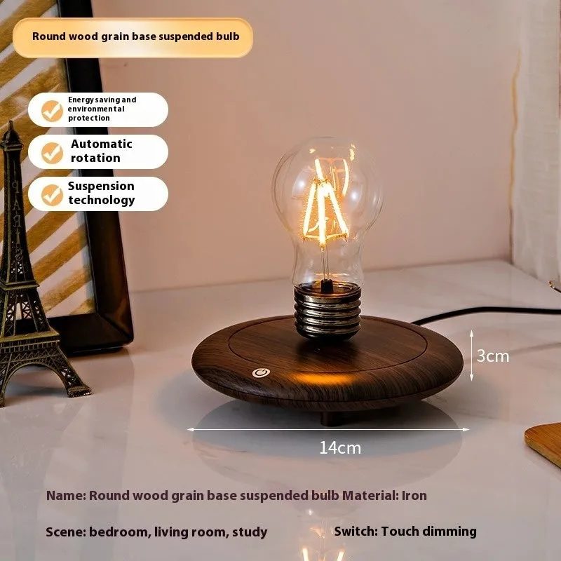 Creative small iron suspension bulb night lamp on a black woodgrain base for desktop decoration.