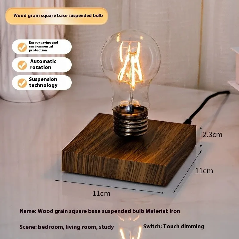 Creative small iron suspension bulb night lamp on a black woodgrain base for desktop decoration.