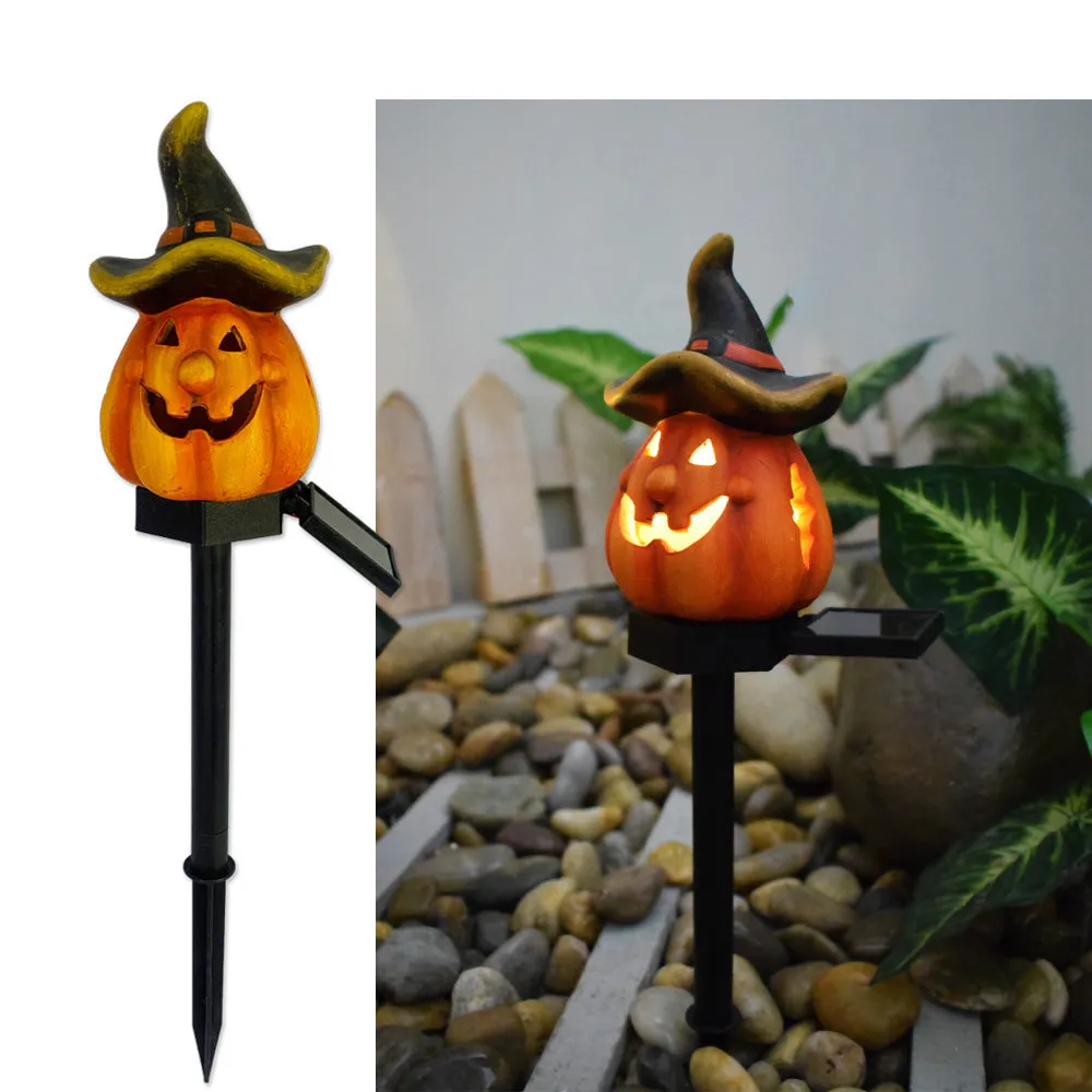 Solar Halloween pumpkin lantern with wizard pumpkin style on a garden path, wrought iron frame