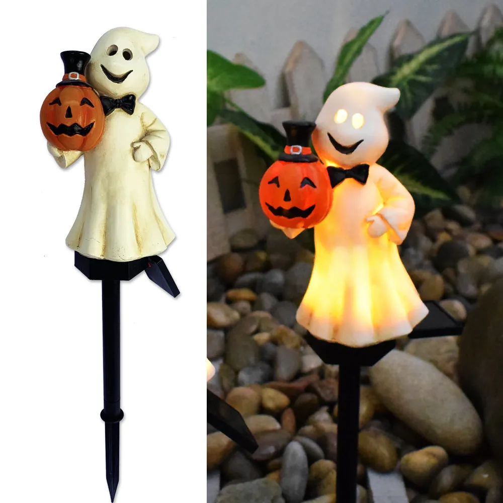 Solar Halloween pumpkin lantern with wizard pumpkin style on a garden path, wrought iron frame
