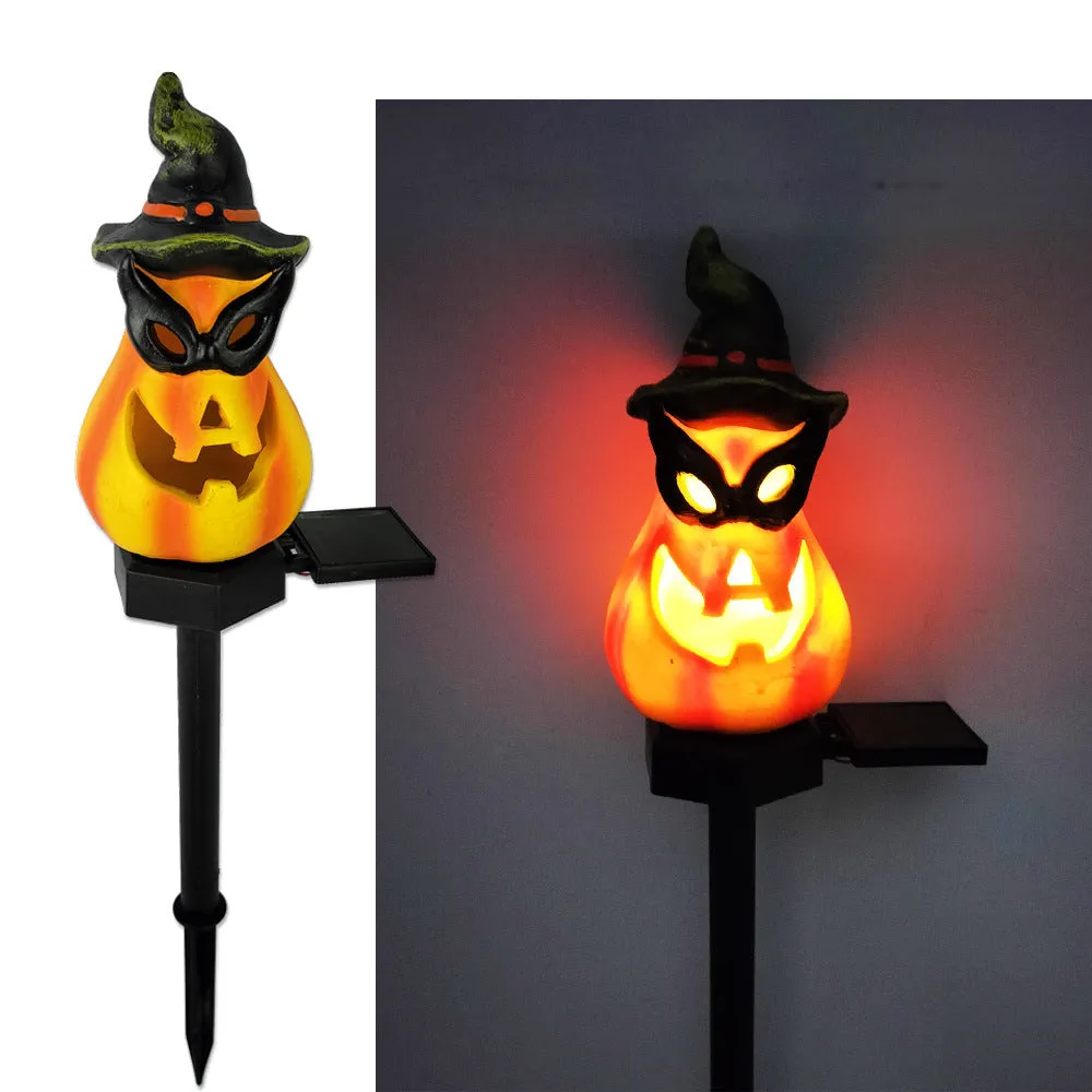 Solar Halloween pumpkin lantern with wizard pumpkin style on a garden path, wrought iron frame