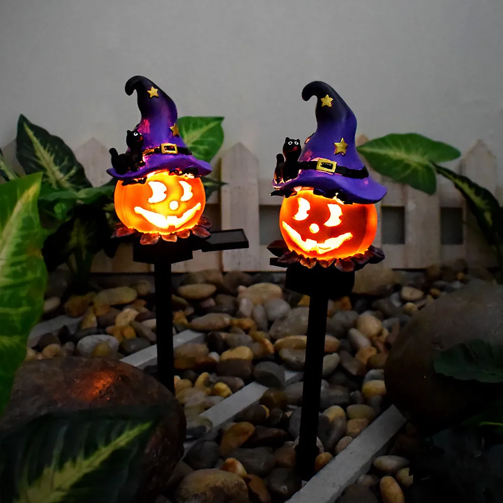 Solar Halloween pumpkin lantern with wizard pumpkin style on a garden path, wrought iron frame